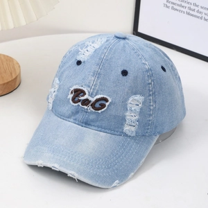 Distressed light blue denim baseball cap with B&G 3D embroidery in a cozy home setting