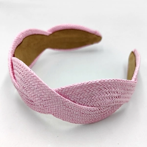 Close-up of pink woven raffia headband showing intricate braided texture and detail