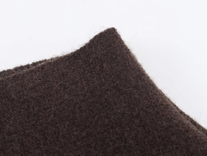 Primo piano del tessuto a maglia marrone scuro con trama morbida e fibre fini