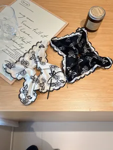 Detail of vintage lace hair scrunchies with rose pattern, bow, and pearl pendant