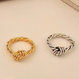 Detailed close-up of minimalist gold and silver knotted rope design rings in 925 sterling silver