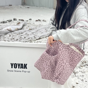 Detailed shot of pink leopard print suede tote bag with large pocket in snow scene