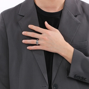 Close-up of a silver spinner ring with Viking runes worn by a male model in a suit