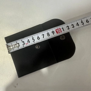 Macro detail of black velvet jewelry pouch with silver snaps showing 11cm width measurement