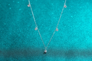 Detailed view of S925 sterling silver chain featuring five round moissanite pendants