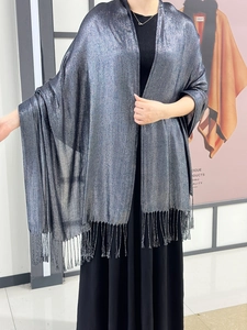 Detail of silver metallic shawl showing shimmery fabric and delicate fringe tassels