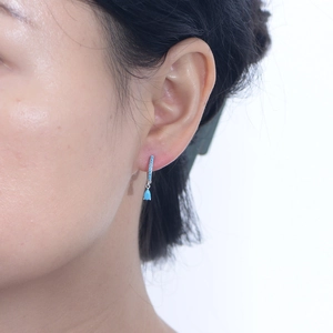 Elegant S925 sterling silver turquoise drop earrings worn by a model on white background
