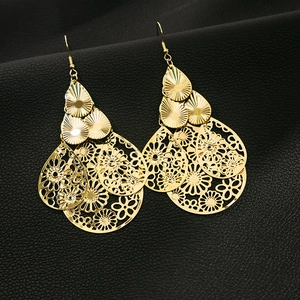 Gros plan détaillé de boucles d'oreilles dorées multicouches en forme de larme sur cuir
