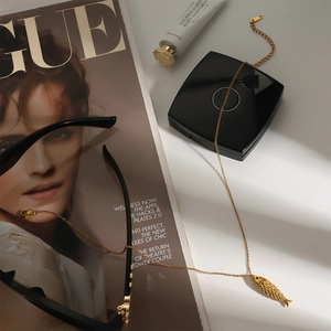 Detailed macro view of a golden fish pendant necklace styled with high-end fashion props