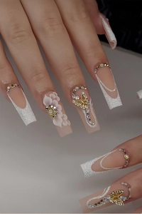 Détails de faux ongles longs cercueil avec fleurs 3D et breloques papillon dorées