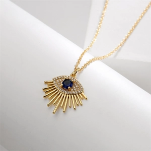 Macro shot of gold evil eye pendant with blue gemstone and pavé cubic zirconia