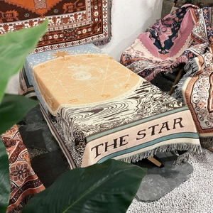 Close-up of bohemian woven The Star tarot blanket with jacquard texture and tassels