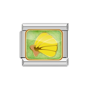 Dettaglio macro dello charm in acciaio inossidabile argento con glitter verdi e conchiglia