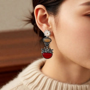 Detailed view of vintage flower earrings with amber bead and red semi-circle pendant