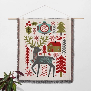 Detail of woven Christmas tapestry featuring reindeer, red cabin and fringe edges