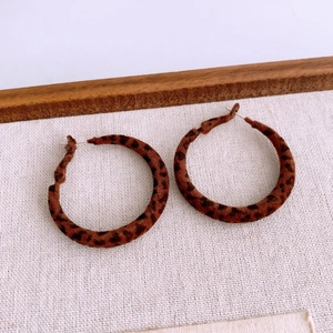 Detailed view of leopard print fabric texture on vintage-style round hoop earrings