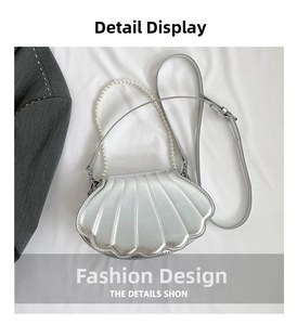 Close-up of shell-shaped crossbody bag with pearl handle and ribbed faux leather texture