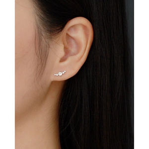 Close-up of elegant s925 silver curved stud earrings with sparkling cubic zirconia on ear