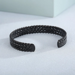 Close-up of matte black stainless steel cuff with industrial woven texture detail