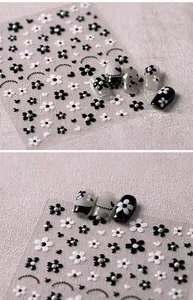 Detail of vintage French black and white floral nail stickers with pearl accents on nails