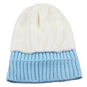 Detail of blue rib-knit brim and white plush faux fur crown on a warm winter beanie
