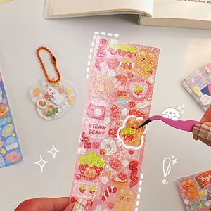 DIY strawberry bear laser stickers set for craft decoration with tweezers on white table