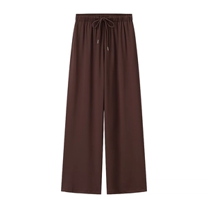 Dettaglio dei pantaloni in maglia marrone scuro a gamba larga con coulisse in vita