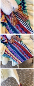 Detail view of colorful geometric knit poncho with faux fur collar and tassel fringe edges