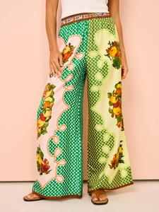 Detail of high-waist floral wide-leg pants with colorful fruit and polka dot print pattern