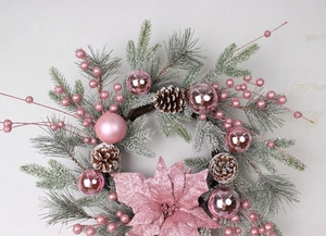 Detail of pink Christmas wreath featuring frosted pine needles and shiny baubles