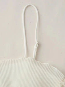 Détail du tissu plissé blanc et de la fine bretelle réglable de ce caraco en dentelle chic