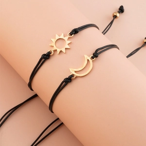 Detail of adjustable black woven sun and moon charms on a couple's bracelet set