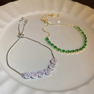Close-up of adjustable bracelets with drop-shaped cubic zirconia in gold and silver