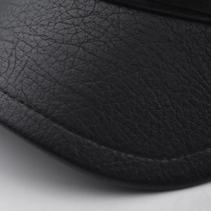 Close-up of black PU leather with litchi texture and neat stitching on a military hat