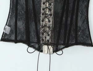 Close-up of black lace corset top with adjustable criss-cross lacing and metal eyelets