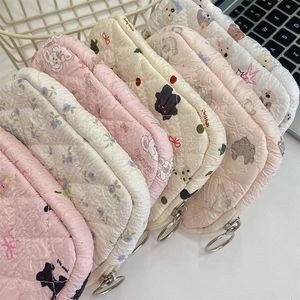 Quilted floral coin purses with cute bear and cat patterns in a metal wire basket