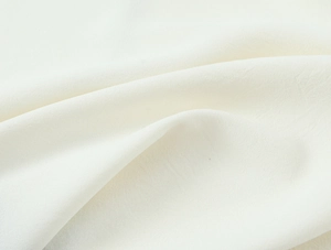 Close-up detail of cream textured crepe fabric with high-quality linen blend weave