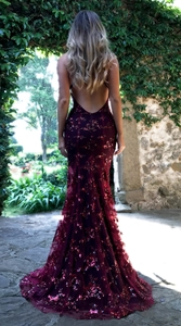 Macro detail of the backless burgundy sequined evening gown with shimmering mermaid hemline