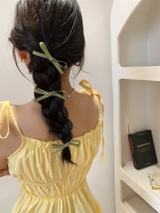 Drie groene kanten strik haarspelden gestyled in een gevlochten kapsel voor dames