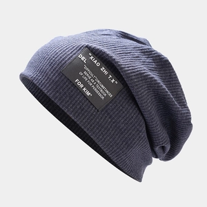 Détail macro du bonnet en tricot bleu marine et de l'écusson rectangulaire brodé