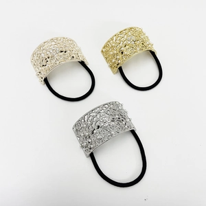 Detail of three metal ponytail holders with pearls and rhinestones in gold and silver