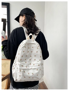 Detailed side view of floral backpack with pink roses and front zipper pocket