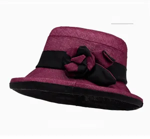Détail d'un chapeau de soleil bordeaux avec rose élégante en tissu et ruban noir