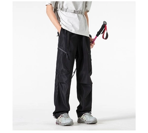 Detailed close-up of side cargo pockets and technical fabric on black cargo pants