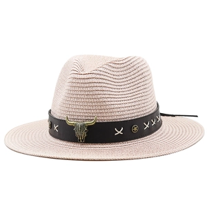 Detail of bohemian straw hat with leather band and vintage bull skull metal ornament