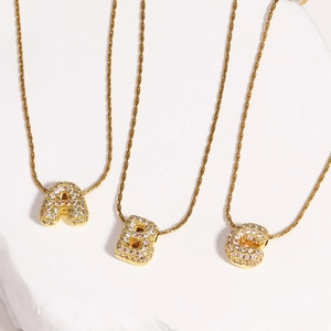 Colliers lettres bulles A B C dorées avec zircons micropavés sur des chaînes texturées