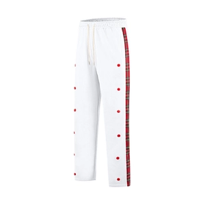 Detail shot of men's white casual trousers featuring red and green plaid side stripe accents