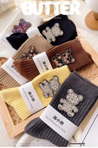 Close-up of ribbed cotton socks featuring sparkly rhinestone bear patches in various colors