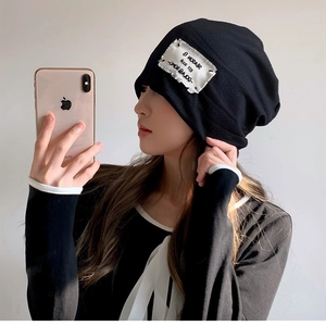 Women's black knitted slouchy beanie with white letter patch for casual spring wear