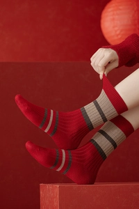Détail de chaussettes en laine rouge avec motif flocon Fair Isle portées par un mannequin